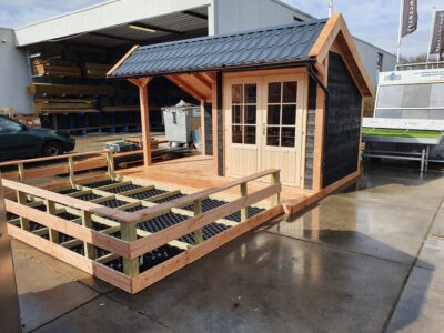 Zwart houten tuinhuis met zadeldak, op een houten vlonder